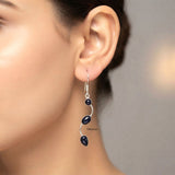 Curved S-shaped silver earrings with sparkling blue stones