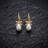 Gold-plated sterling silver bow earrings with pearl drop detail