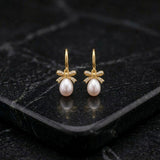 Elegant pearl bow earrings in 92.5 silver with fixed hook closure